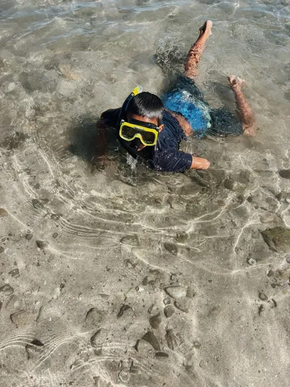 Niño con careta explorando una poza