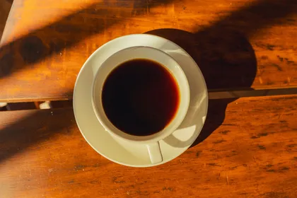 Taza de café sobre una mesa de madera
